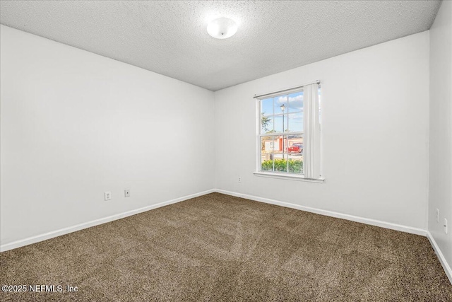 spare room featuring carpet floors and a textured ceiling