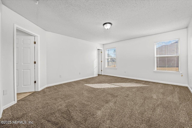 empty room with carpet floors and a textured ceiling