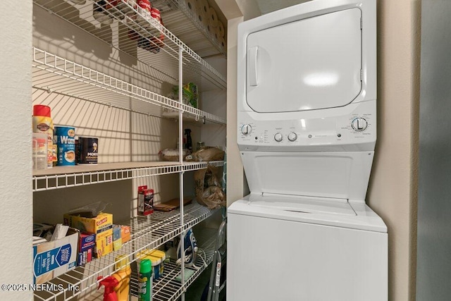 washroom with stacked washing maching and dryer