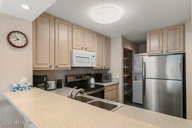 kitchen with stainless steel appliances, stacked washer / dryer, sink, and light brown cabinetry