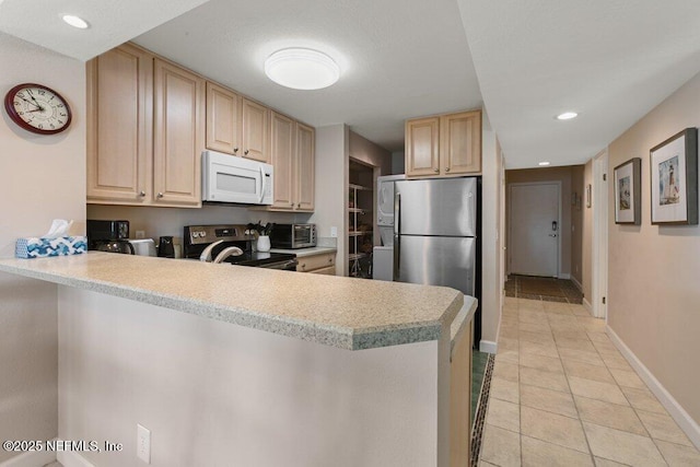 kitchen featuring light brown cabinetry, light tile patterned floors, stainless steel appliances, and kitchen peninsula