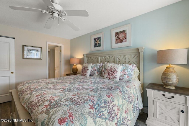 bedroom with dark hardwood / wood-style flooring and ceiling fan