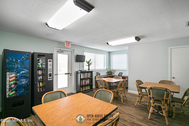 dining space with dark hardwood / wood-style floors and a textured ceiling