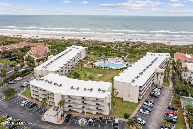 birds eye view of property with a water view and a beach view