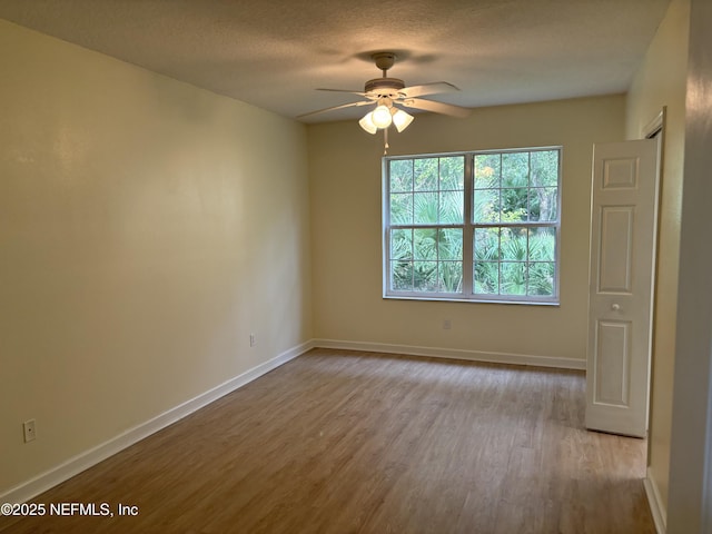 empty room featuring ceiling fan, light hardwood / wood-style floors, and a textured ceiling