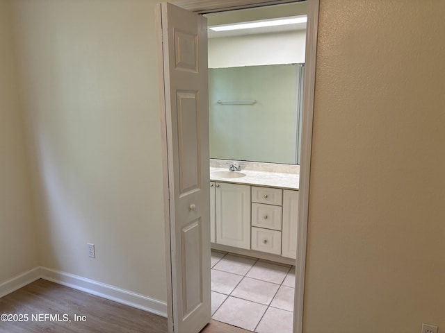 hallway featuring light tile patterned flooring and sink