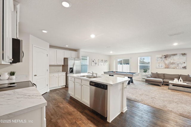 kitchen featuring stainless steel appliances, white cabinetry, sink, and a center island with sink