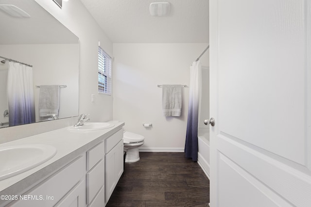 full bathroom with toilet, wood-type flooring, a textured ceiling, vanity, and shower / bath combo with shower curtain