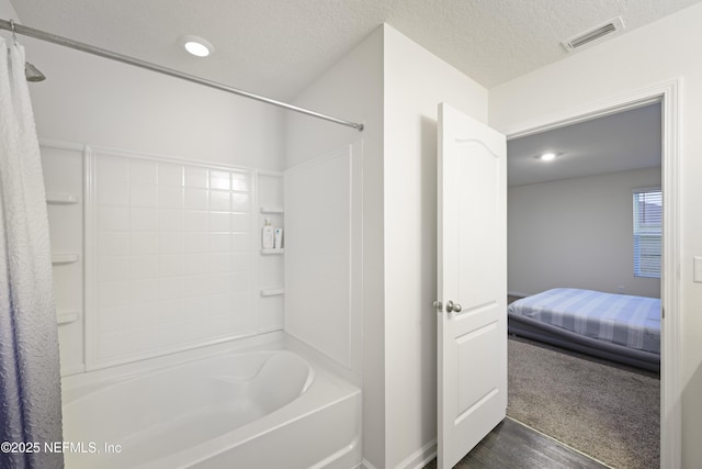 bathroom featuring hardwood / wood-style flooring, a textured ceiling, and shower / bath combo with shower curtain