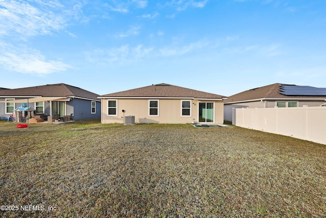 back of house featuring central AC unit and a yard