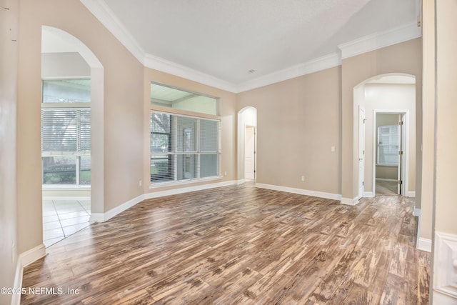 unfurnished room featuring baseboards, ornamental molding, and wood finished floors