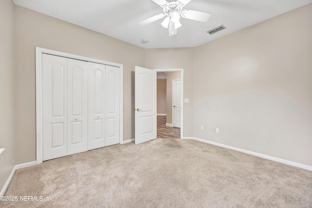 unfurnished bedroom featuring a closet, visible vents, light carpet, and baseboards