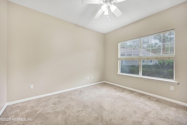 unfurnished room with ceiling fan, a textured ceiling, carpet flooring, and baseboards