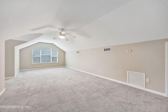 bonus room with lofted ceiling, baseboards, light carpet, and visible vents