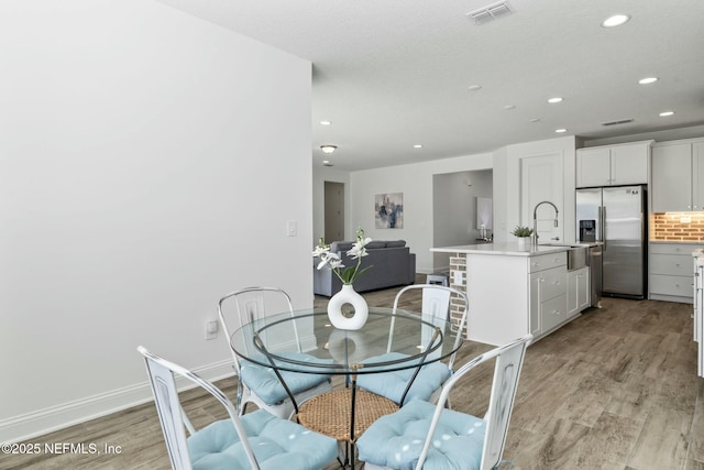 dining room with sink and light hardwood / wood-style flooring