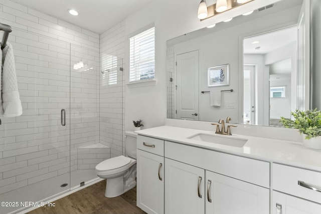 bathroom featuring hardwood / wood-style flooring, vanity, toilet, and walk in shower