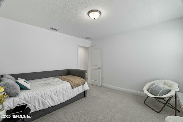 carpeted bedroom featuring a textured ceiling