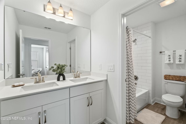 full bathroom with vanity, hardwood / wood-style flooring, toilet, and shower / bath combo with shower curtain