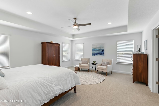 bedroom featuring a tray ceiling, carpet flooring, multiple windows, and recessed lighting