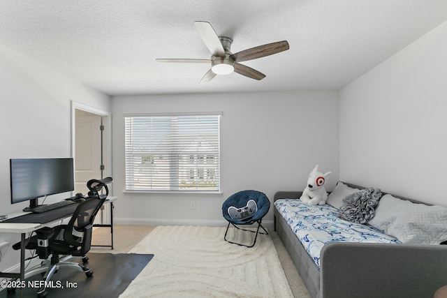 carpeted bedroom featuring baseboards, a ceiling fan, and a textured ceiling