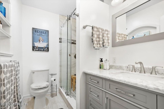 bathroom featuring vanity, toilet, and a shower with shower door