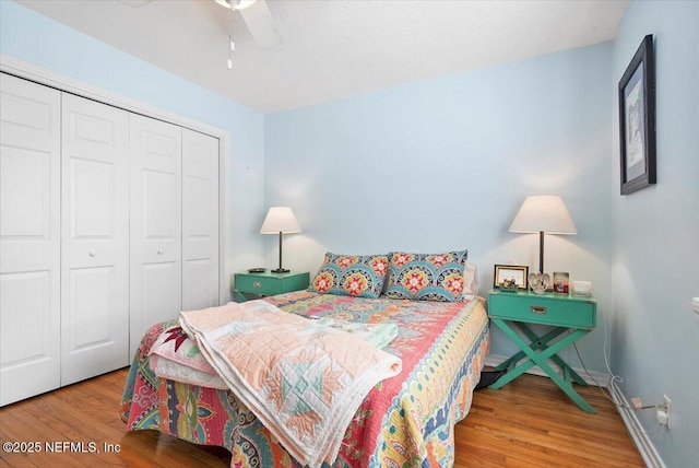 bedroom with hardwood / wood-style flooring, a closet, and ceiling fan