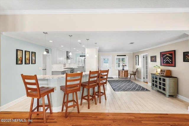 dining area with crown molding and light wood-type flooring