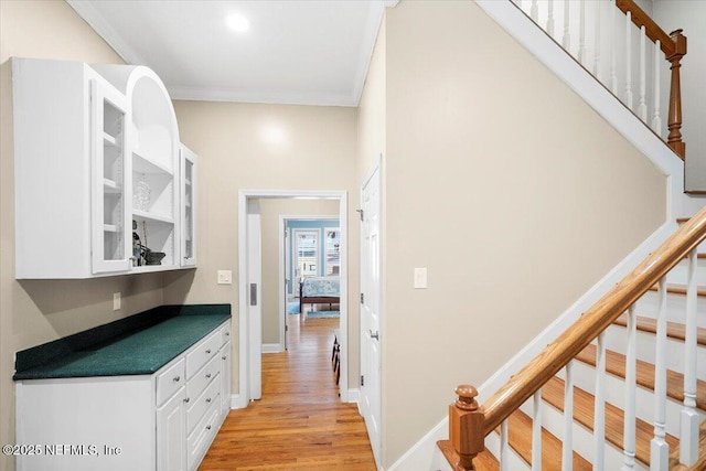 interior space featuring crown molding and light hardwood / wood-style flooring