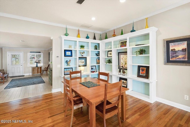 dining area featuring hardwood / wood-style flooring and ornamental molding