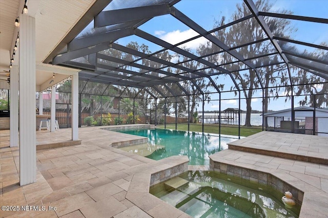 view of pool with an in ground hot tub, a patio area, and glass enclosure