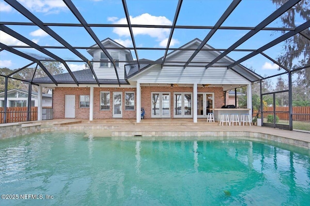 view of swimming pool featuring a patio, an outdoor bar, and glass enclosure