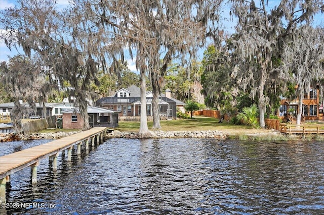 dock area featuring a water view and a lawn