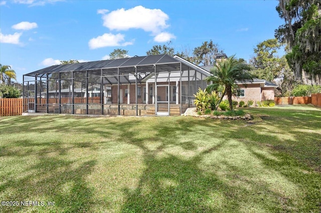 back of house featuring a lanai and a yard