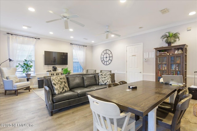 dining area with crown molding, ceiling fan, and light hardwood / wood-style floors