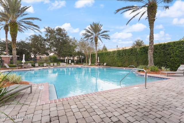 view of swimming pool with pool water feature and a patio