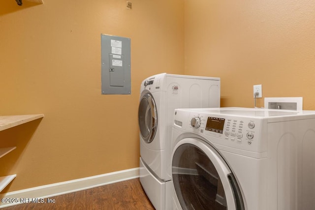 washroom featuring wood-type flooring, electric panel, and washing machine and dryer