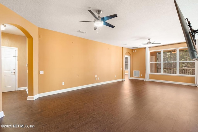 empty room with dark wood-type flooring, a textured ceiling, and ceiling fan