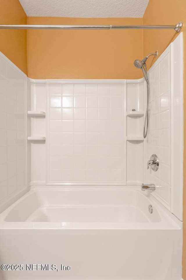 bathroom featuring shower / tub combination and a textured ceiling