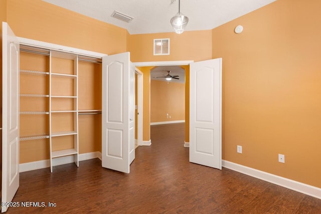 unfurnished bedroom featuring dark hardwood / wood-style flooring and a closet