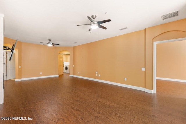 spare room featuring ceiling fan, dark hardwood / wood-style flooring, and washing machine and clothes dryer