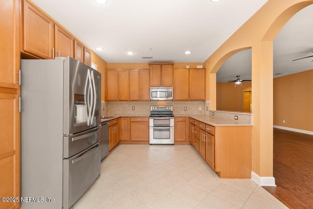 kitchen featuring sink, tasteful backsplash, light brown cabinets, appliances with stainless steel finishes, and ceiling fan