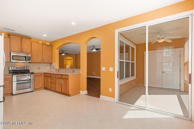 kitchen featuring tasteful backsplash, appliances with stainless steel finishes, and ceiling fan