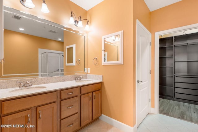 bathroom featuring vanity, a shower with shower door, and tile patterned floors