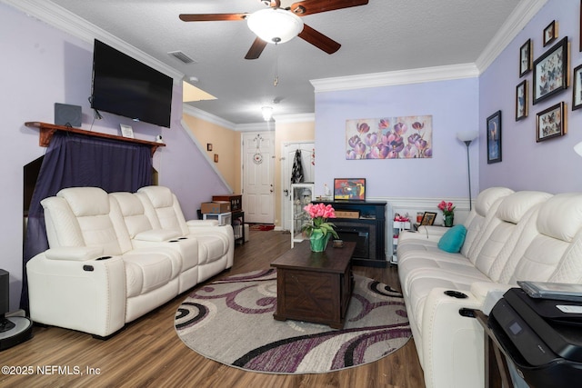 living room with hardwood / wood-style floors, crown molding, a textured ceiling, and ceiling fan