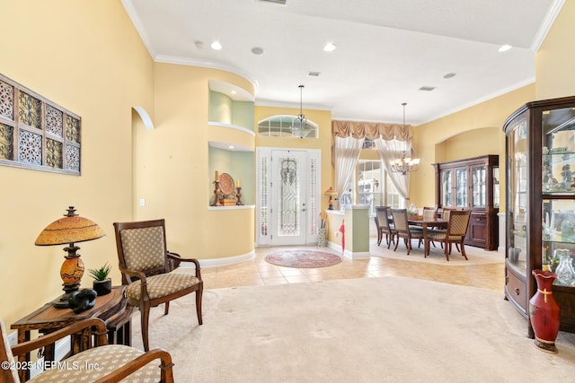 tiled entrance foyer featuring a notable chandelier and crown molding