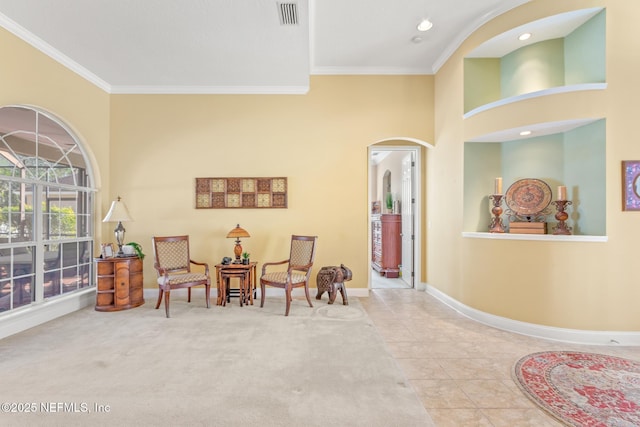 sitting room featuring a high ceiling, ornamental molding, and light tile patterned flooring