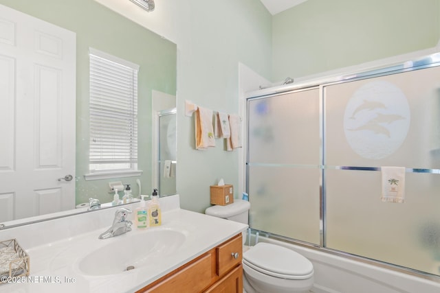 full bathroom featuring vanity, shower / bath combination with glass door, and toilet