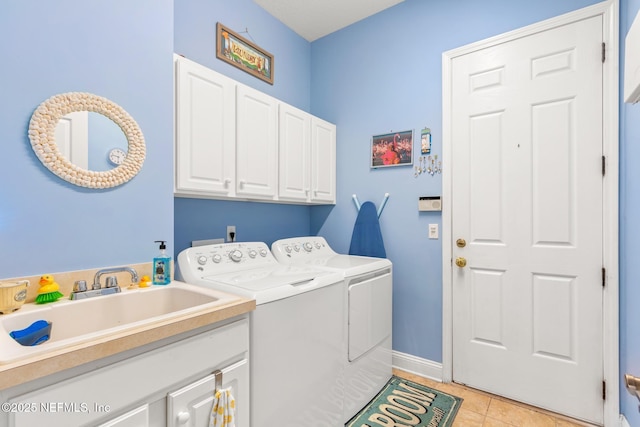 washroom with cabinets, sink, washer and dryer, and light tile patterned floors