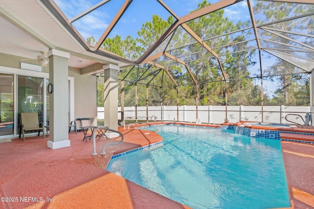 view of swimming pool featuring a patio, an in ground hot tub, ceiling fan, and glass enclosure