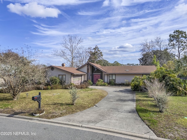 ranch-style home with a garage and a front lawn